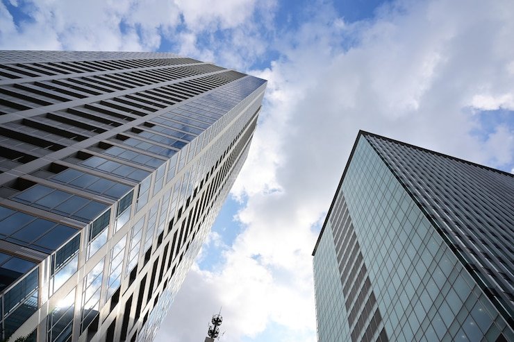 low-angle-shot-modern-glass-skyscrapers-against-cloudy-sky_181624-51675